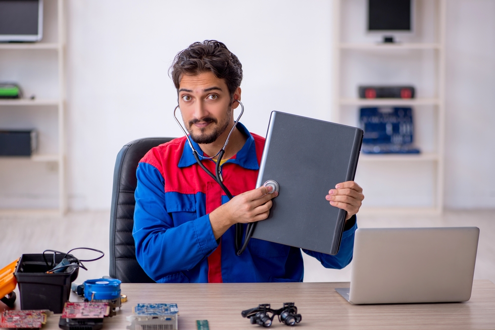 An individual performing a symbolic check-up on a refurbished laptop.